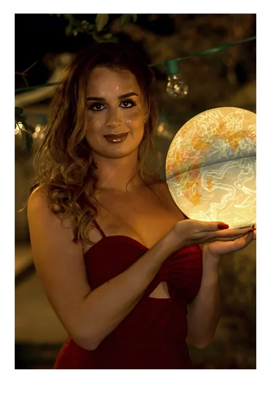 Polaroid de Thais segurando um globo iluminado